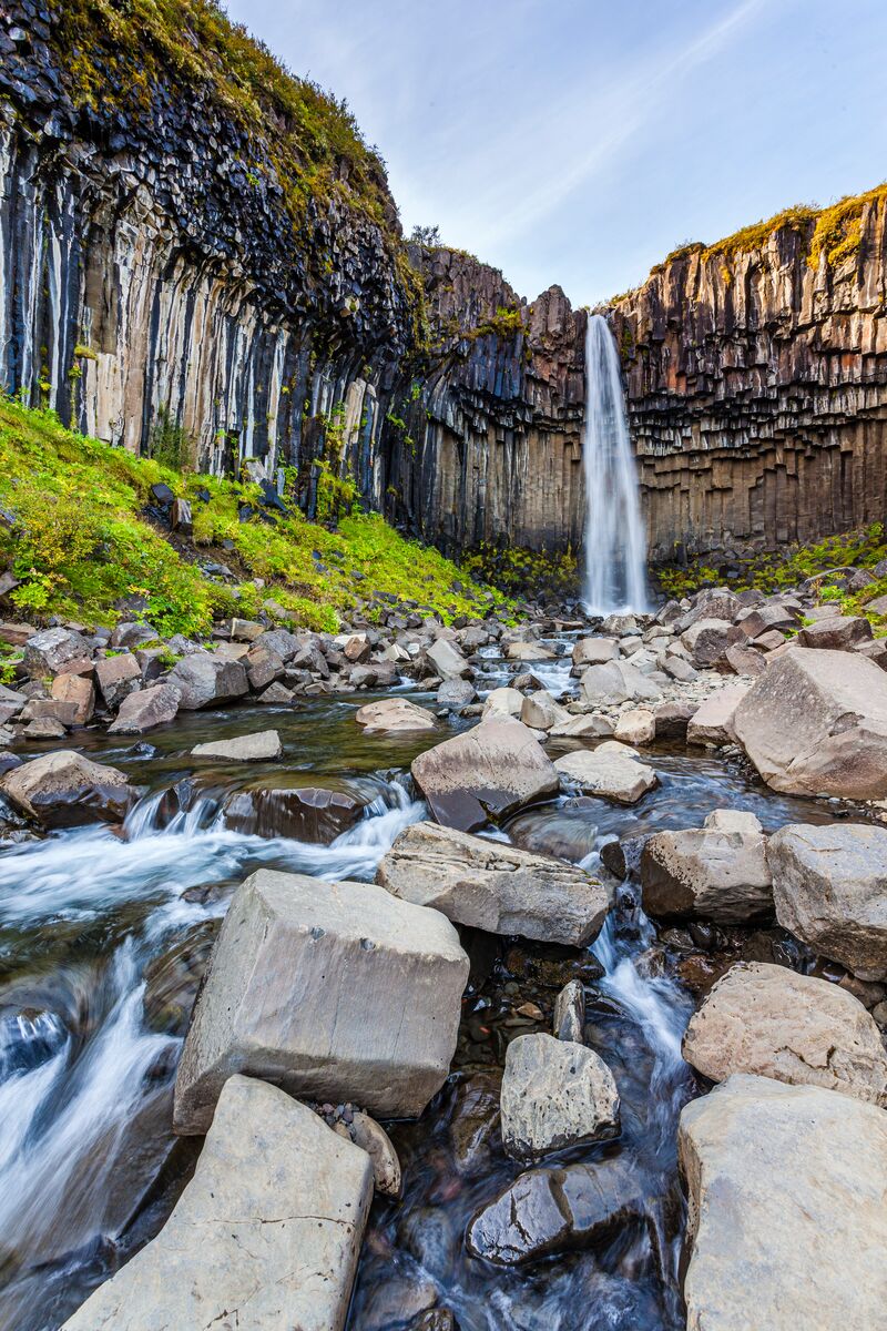 Stream and boulders leading toward Svartifoss and its basalt columns.