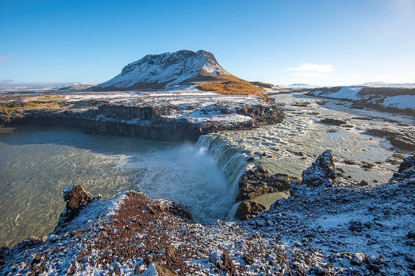 Þjófafoss waterfall on Þjórsá with Búrfell mountain and winter snow in South Iceland.