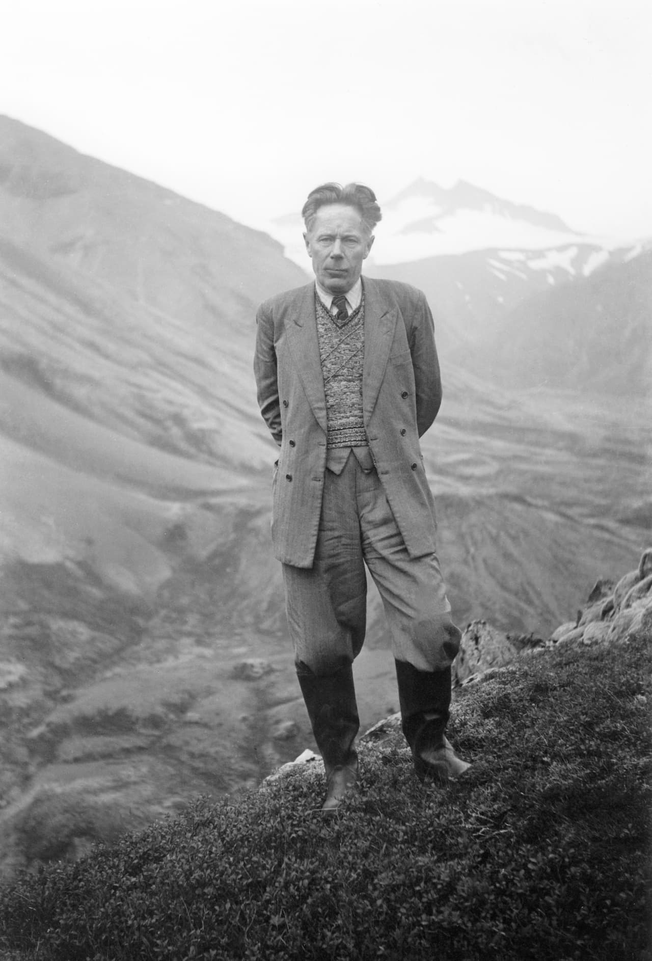 Black-and-white portrait of Þórbergur Þórðarson standing in a mountain landscape.