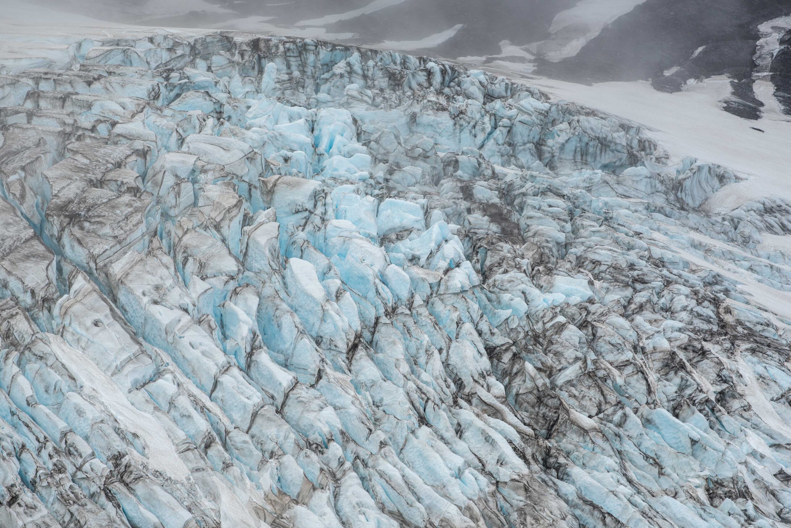 Blue meltwater beside dark volcanic ground below Þórisjökull.