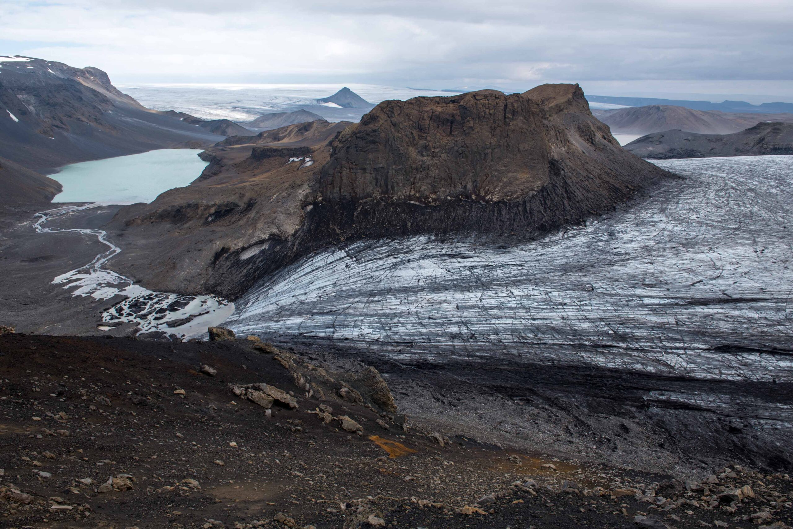 Rocky foreland and ice on Þórisjökull with sparse highland terrain below.