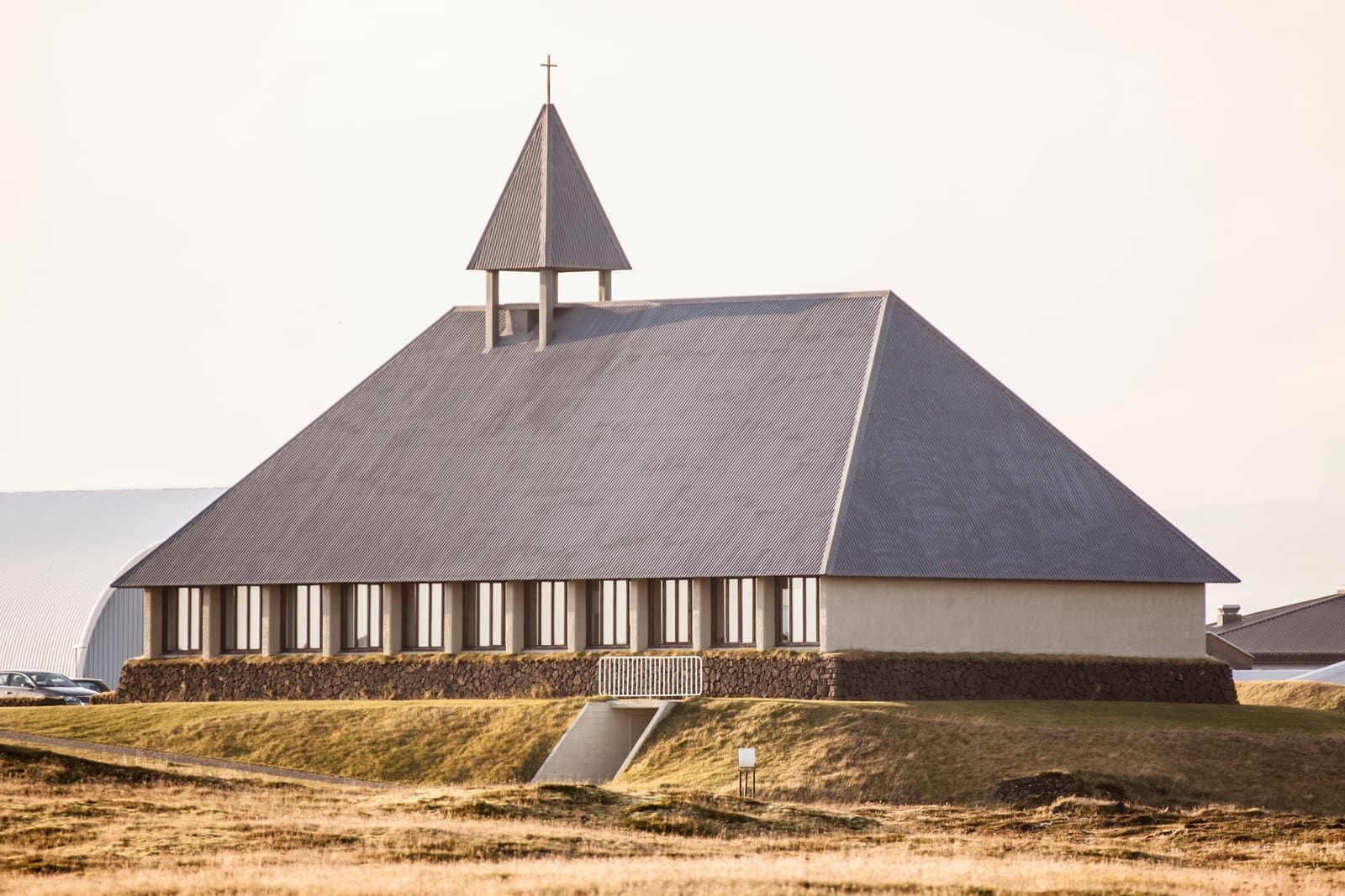 Þorlákskirkja in Þorlákshöfn with low grass and pale coastal light around the church.