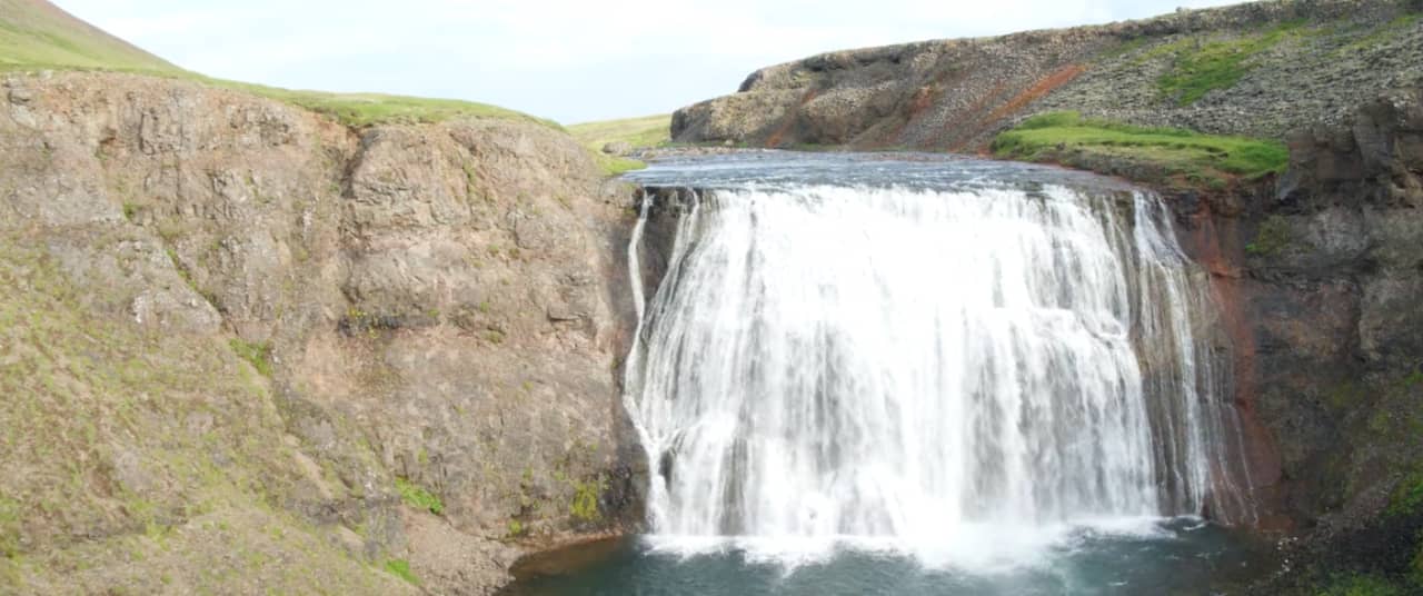 Closer view of the broad Þórufoss waterfall dropping over a rocky ledge.