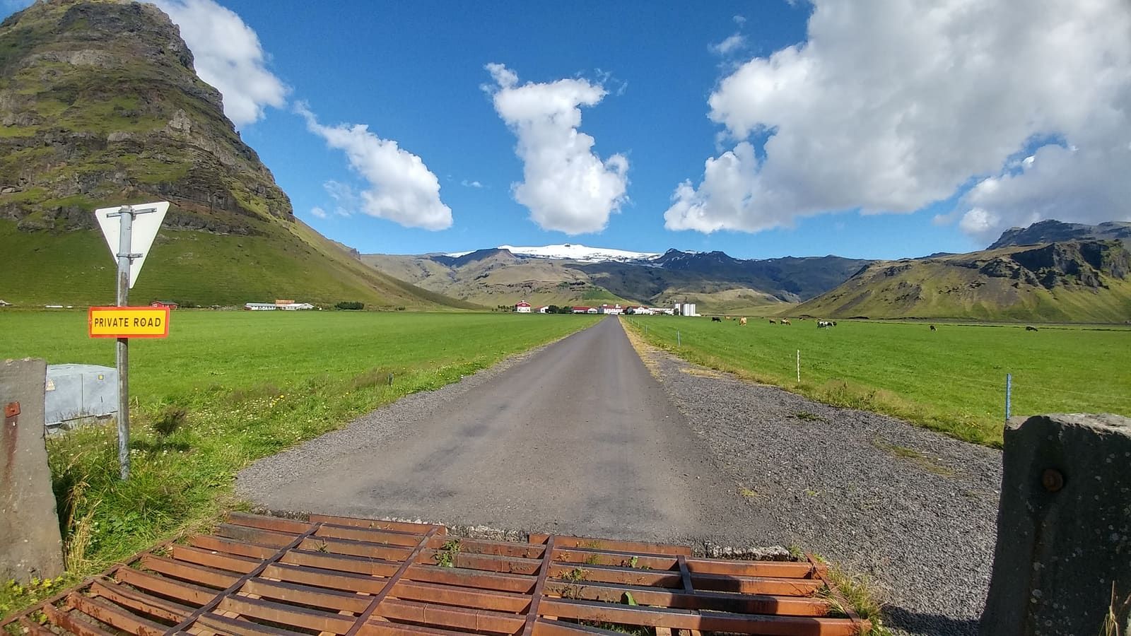 Private road sign near Þorvaldseyri with farm fields and Eyjafjallajökull in the background.