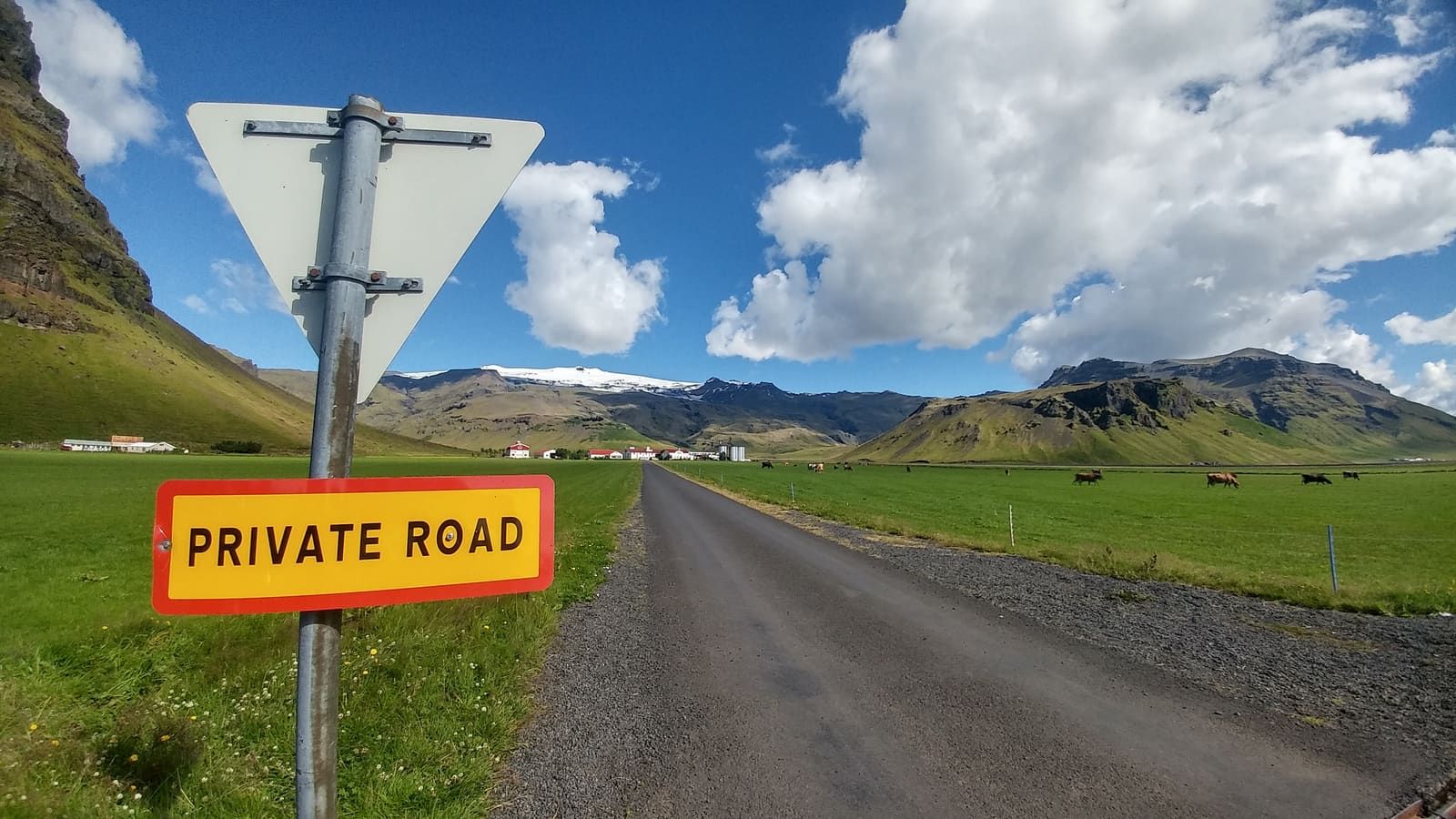 Road toward Þorvaldseyri farm with green fields and Eyjafjallajökull slopes behind it.