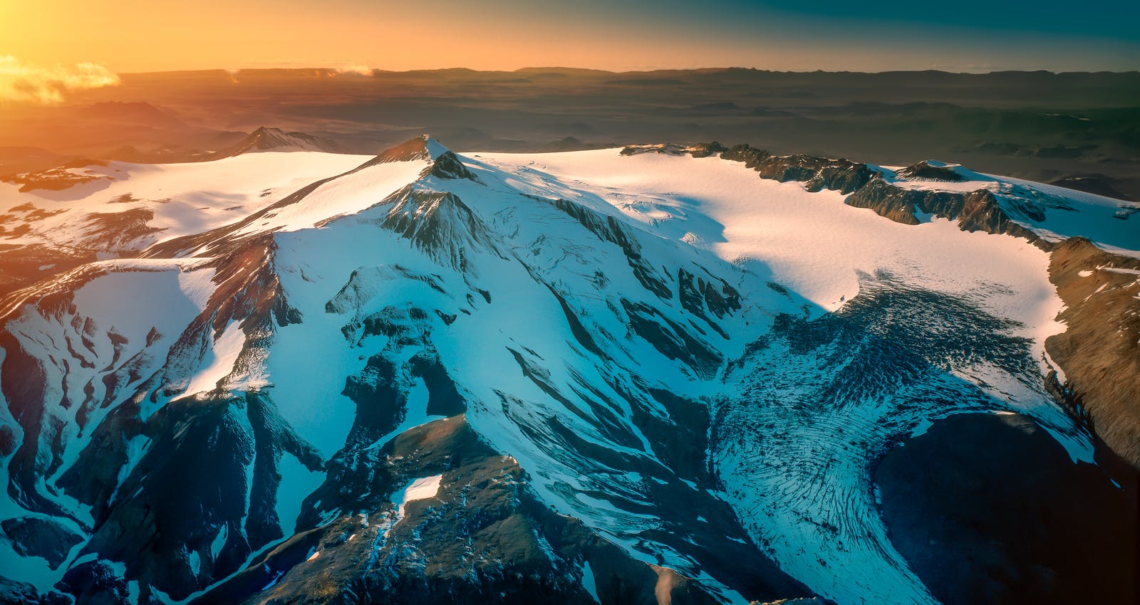 Snow and ice on the Tindfjallajökull caldera with dark volcanic ridges around the glacier.