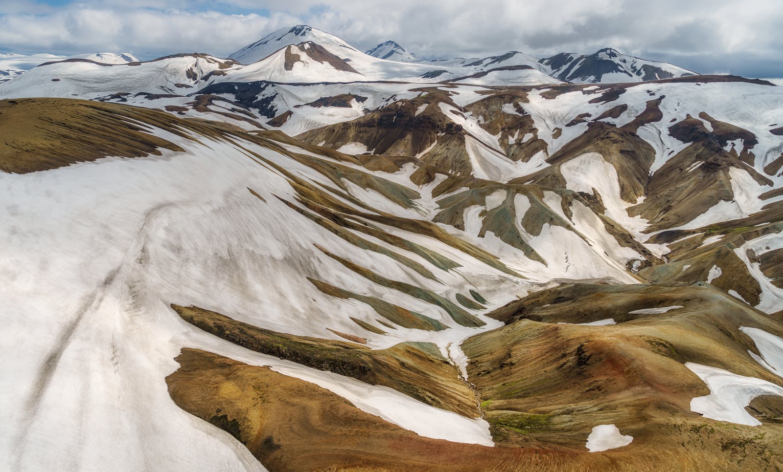 Snow-streaked Torfajökull mountains with muted rhyolite slopes and cloud above the Highlands.