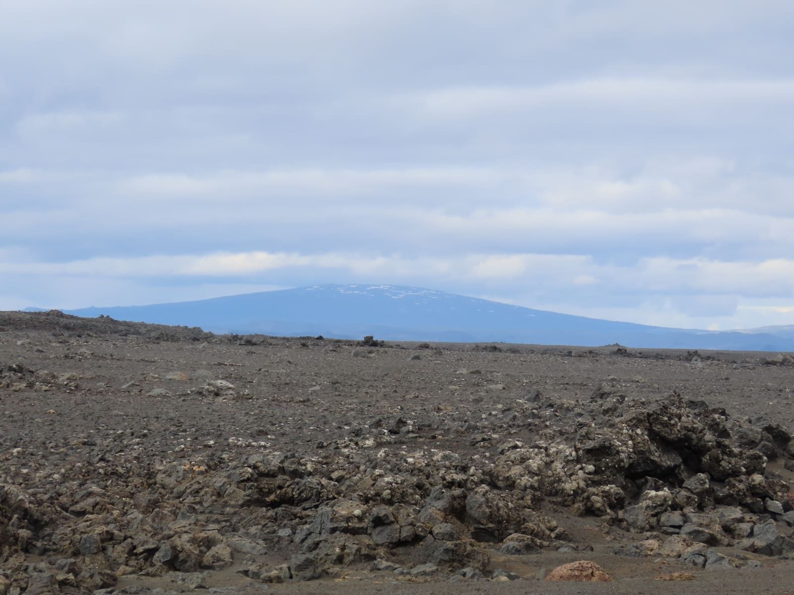 Distant Trölladyngja seen across dark Kverkfjallahraun lava in the Iceland Highlands.