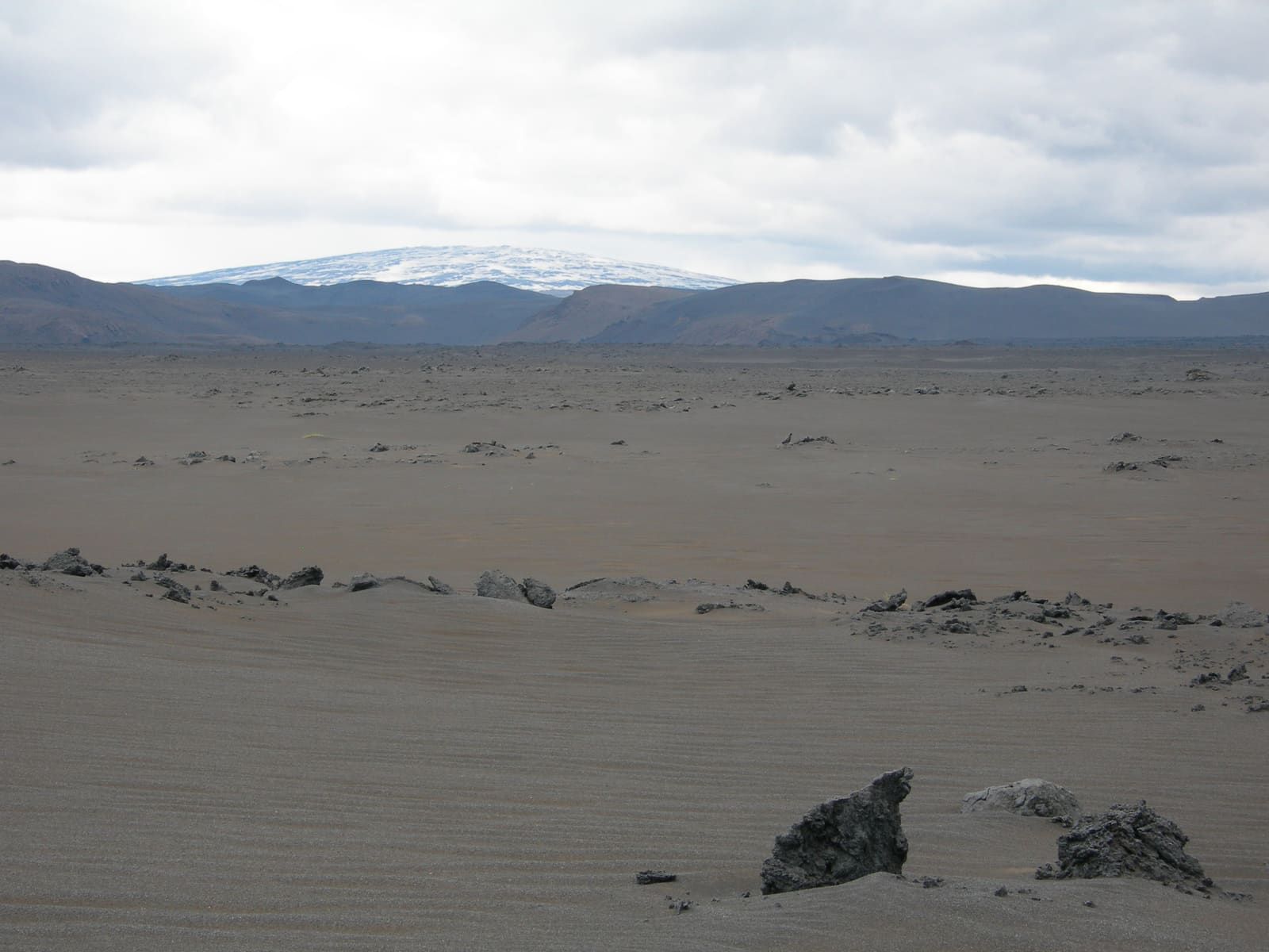 Trölladyngja shield volcano beyond grey lava desert in the north Iceland Highlands.