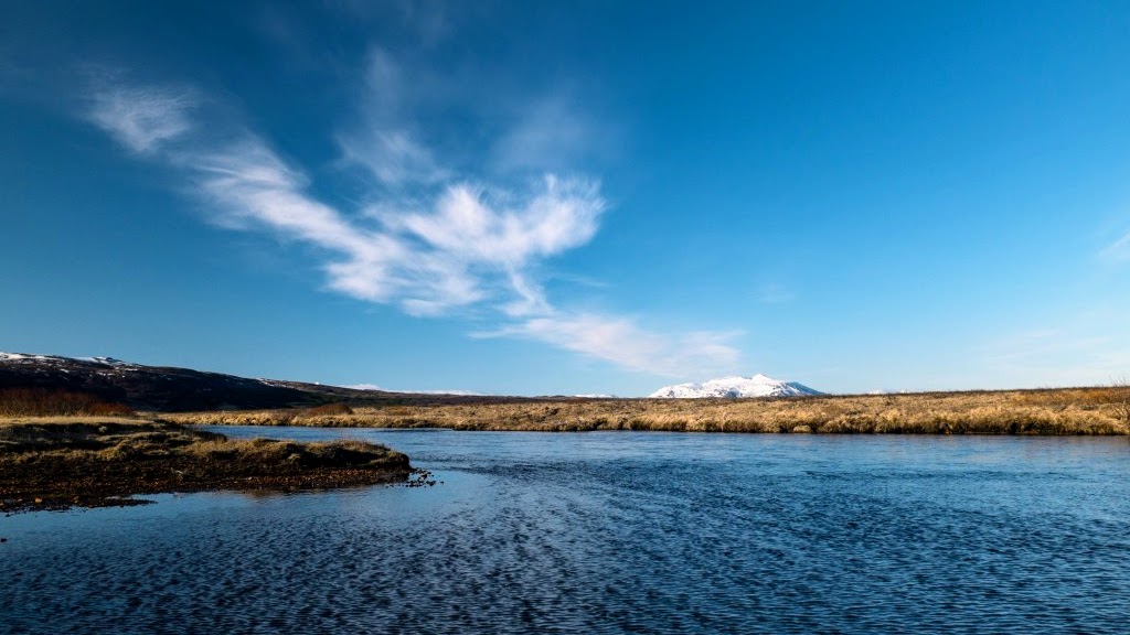 Open stretch of Tungufljót with low banks and distant hills in South Iceland.