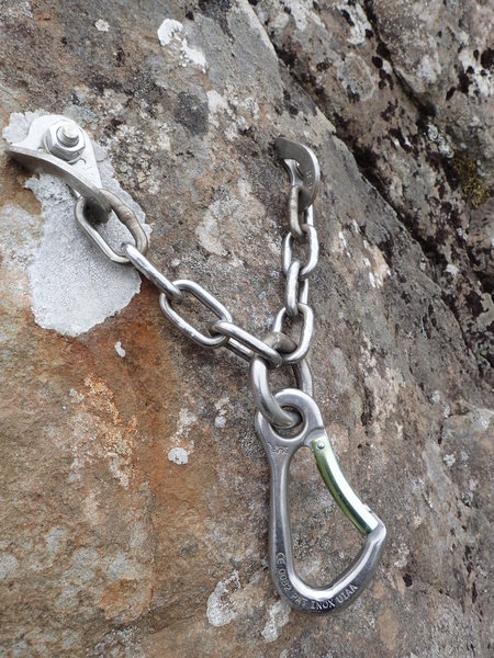 A bolted climbing anchor set into the basalt rock at Valshamar.