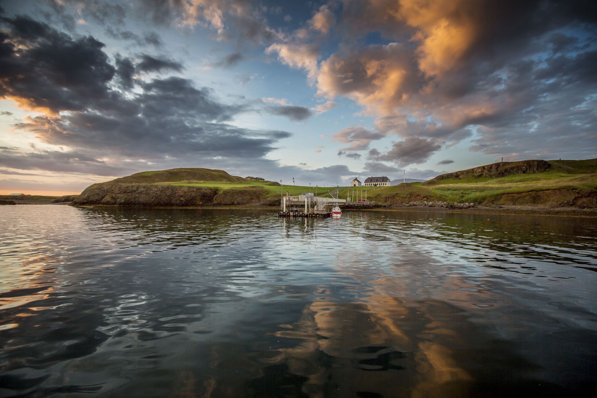 Evening view of Viðey island and a small pier under dramatic clouds