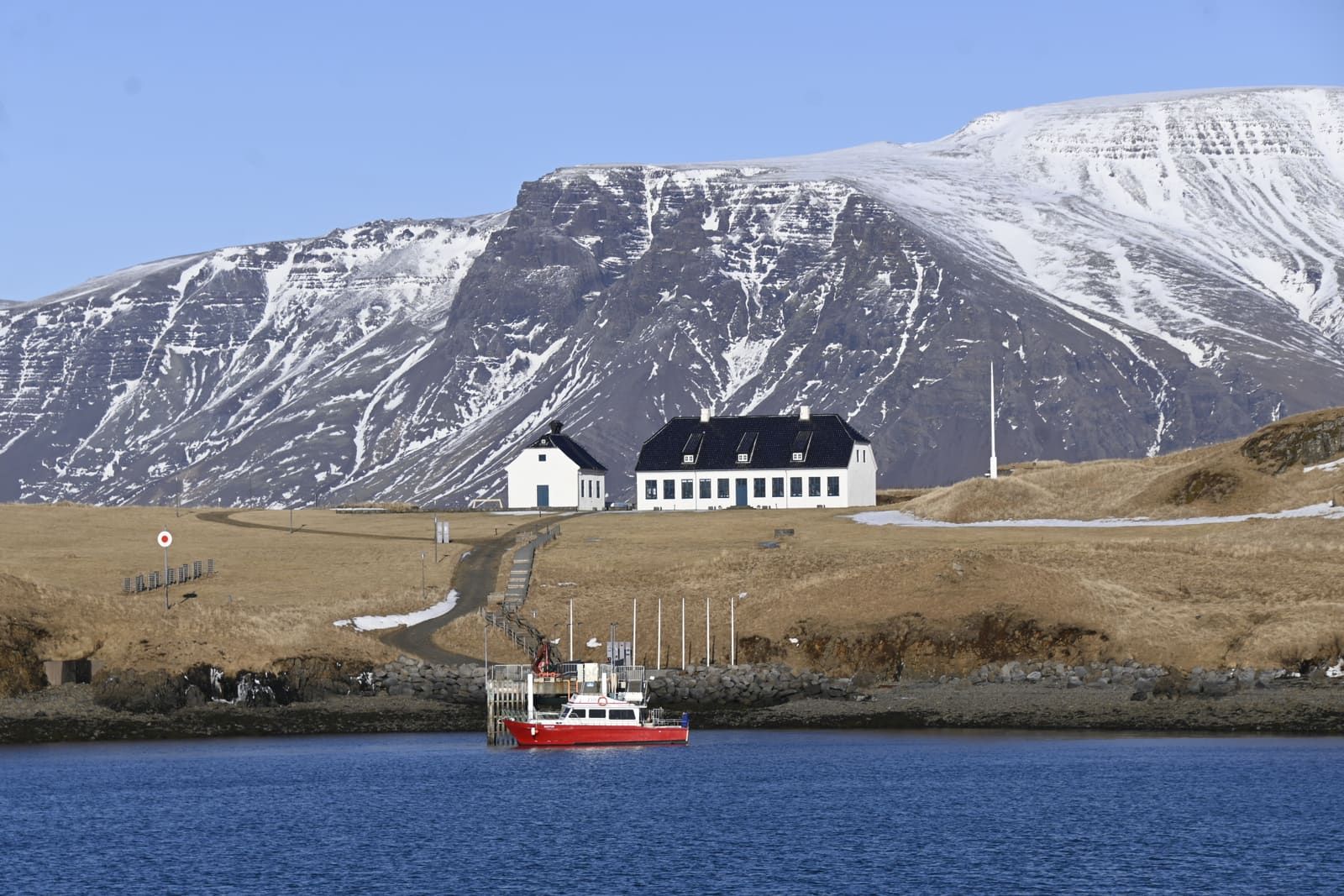 Viðey ferry docked at the island pier with low grassy hills behind it