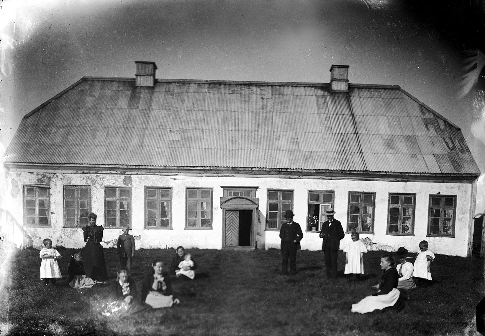 Historic black-and-white photograph of people outside Viðeyjarstofa on Viðey