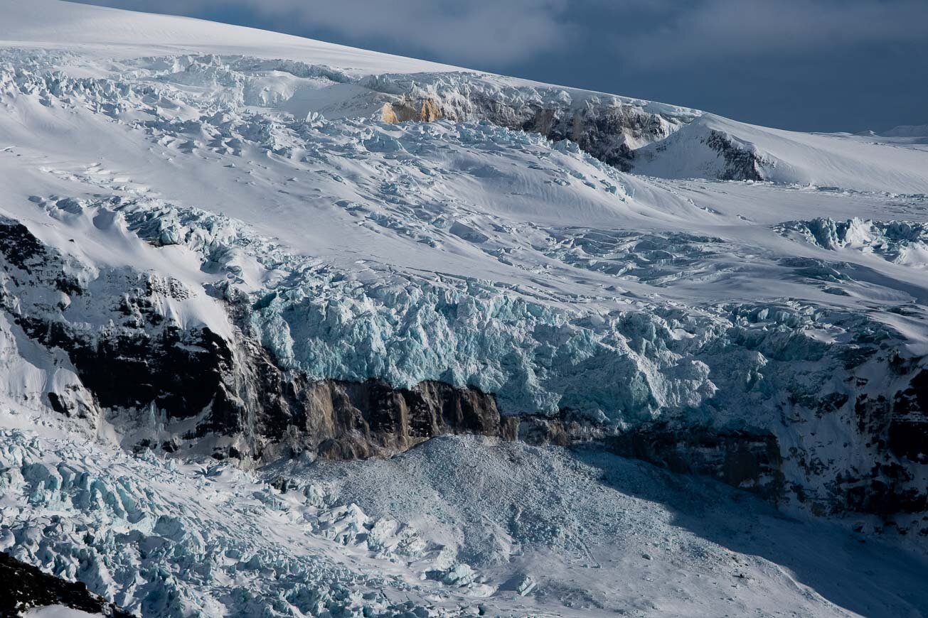 Crevassed upper Virkisjökull valley with steep ice and dark mountain walls.