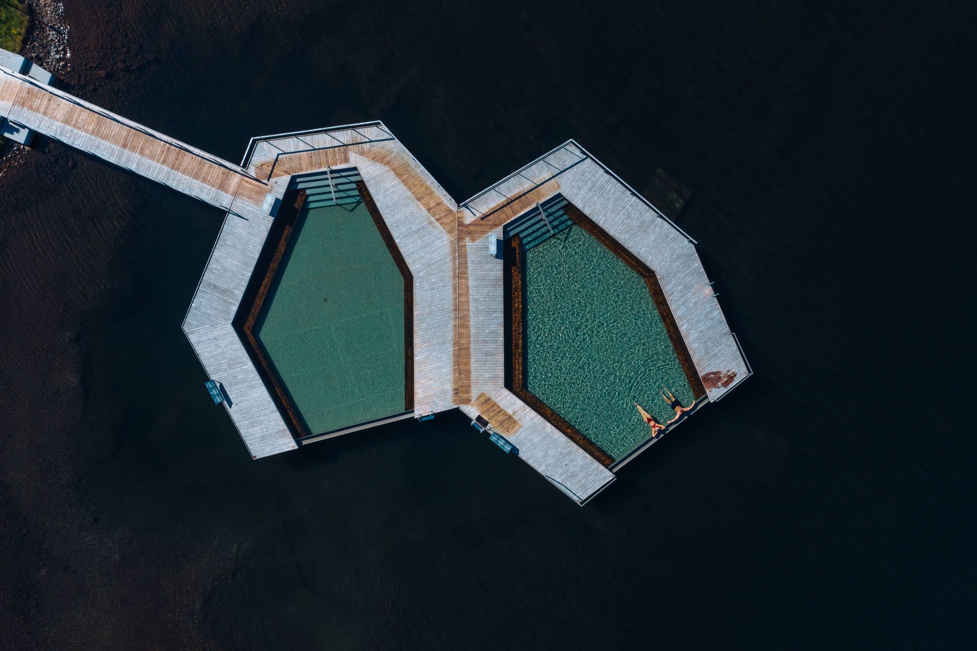 Aerial view of Vök Baths floating pools linked to the shore of Lake Urriðavatn.